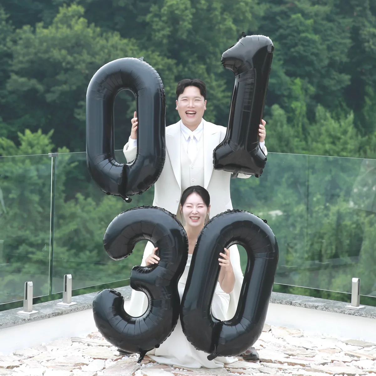 ‘01’과 ‘30’ 숫자 풍선을 든 신랑 이상윤과 신부 김민지가 활짝 웃고 있다